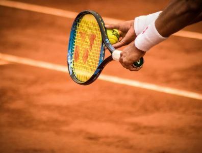 Tennis Holiday – Ready to Play on Court Man holding a tennis racket on a tennis court during a tennis holiday