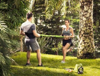 Bespoke Fitness Holiday – Personal Training in Garden Woman exercising with a male personal trainer during a garden fitness session on a bespoke fitness holiday