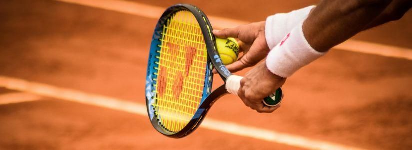 Tennis Holiday – Ready to Play on Court Man holding a tennis racket on a tennis court during a tennis holiday